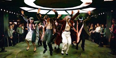 Production image of actors with their hands in the air from Dream Awake: the Deal