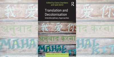 Book cover. "Edited by Claire Chambers and Ipek Demir. Translation and Decolonisation: Interdisciplinary Approaches. Translation Politics and Society". Artwork: writing in three language scripts painted in white, green, teal onto wooden pallets.