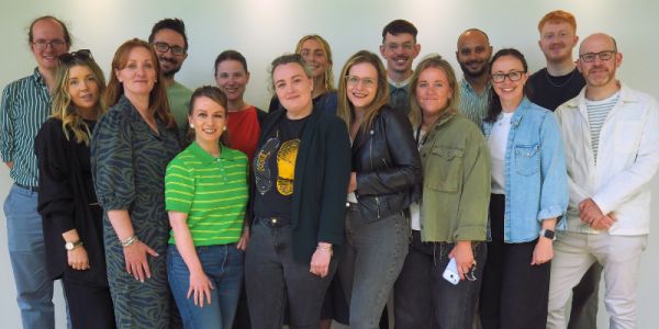 A group of CCJS colleagues smiling against a plain wall on their 2026 Away Day