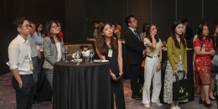 Attendees standing looking towards the stage