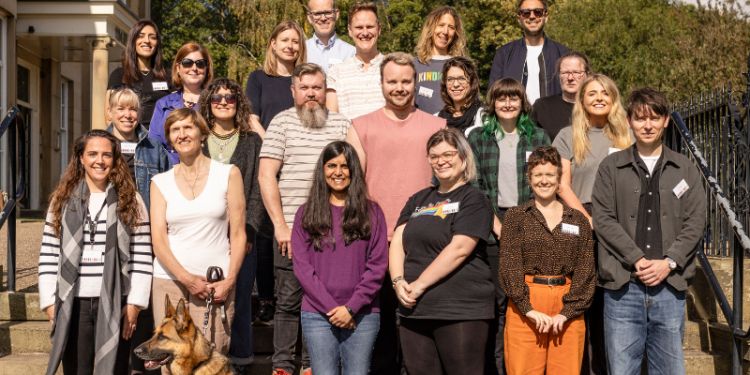 Smiling group photo of LSJ members standing on steps in the sunshine.