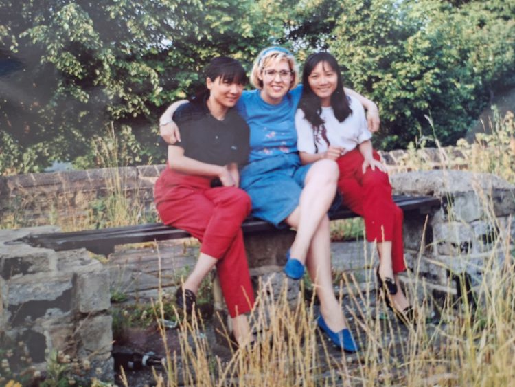 Nancy, May Lin and Pau Lin sitting on a wall in the early 1990s.