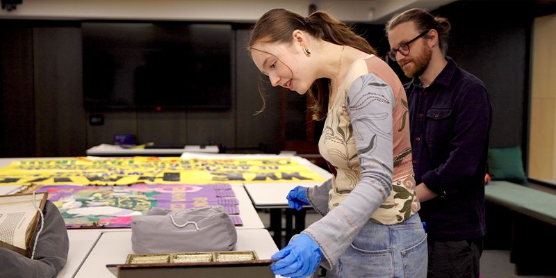A student examining an object in the SSP archive, alongside their tutor