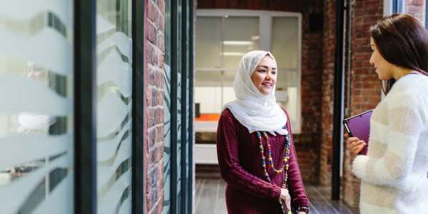 Student chatting in Coach House corridor