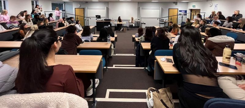 Chrissie and Jodie speaking in front of an audience