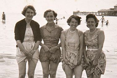 Four ladies paddle at the seaside (1950s image)