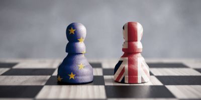Chessboard with two chesspieces - one painted with the EU flag, the other with the Union Jack.