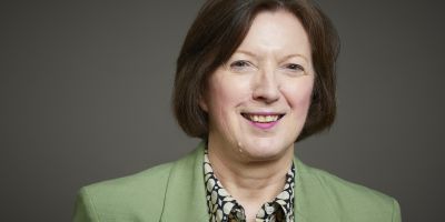 Image of a woman with brown hair in a pale green blazer