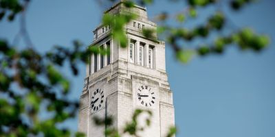 Photo of Parkinson Building through the trees, with leaves in front of it.
