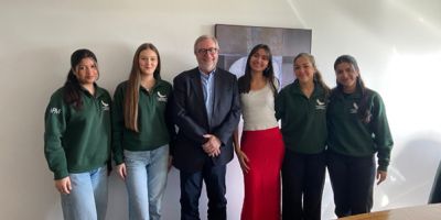 Picture of alum Mark Hughes standing in between a group of students from LawSoc.