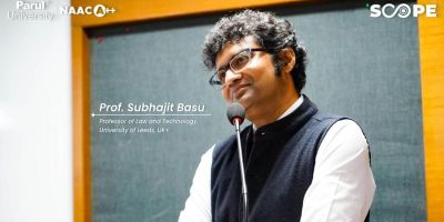 Photo of Professor Basu at a blackboard listening and smiling. Captioned 'Professor Subhajit Basu, Professor of Law and Technology, University of Leeds, UK'. Credit Parul University NAACA++ and SCOPE