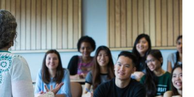 picture of students been taught in a class, with teacher stood at the front