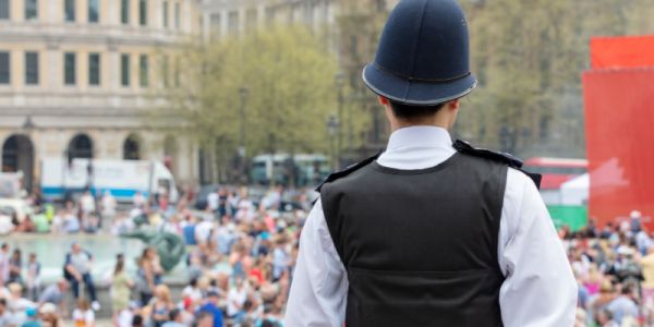 Policeman watching over crowds in Trafalgar Square, London