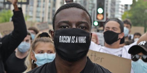 Protester wearing a face mask that says Racism is a virus