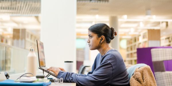 A student works on their laptop in the Laidlaw Library