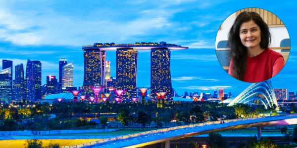 Photo of Singapore's skyline at night. Photo of Dr Blazsek in a circle to the right.