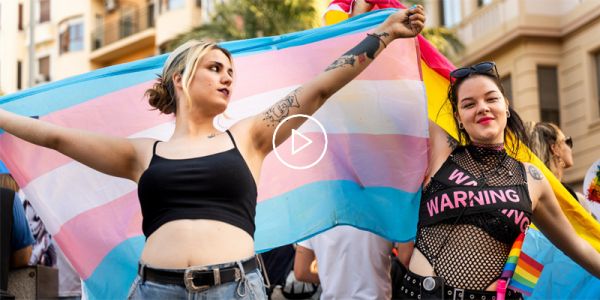 Trans and queer young people at a rally carrying flags