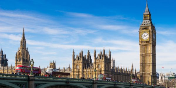 View of houses of Parliament with red buses crossing Westminster Bridge