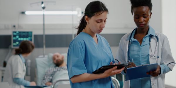 Two medical workers chatting and looking at some notes