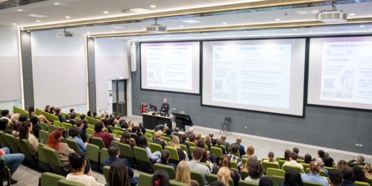 Audience in lecture theatre with Alex Batesmith speaking at the front