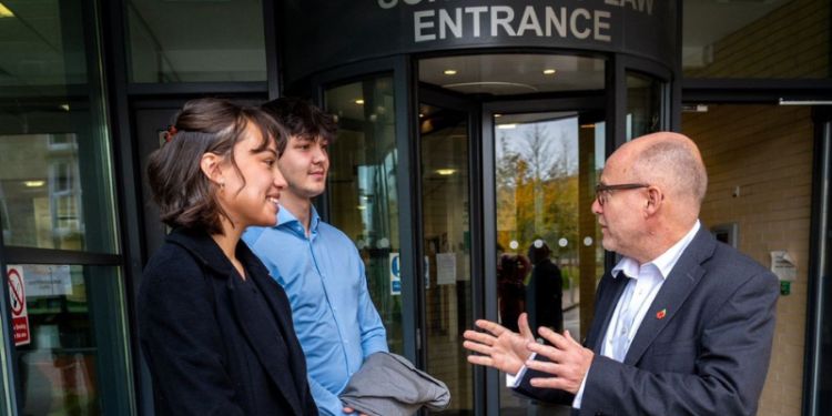 Attorney General and two students chatting outside the entrance to the School of Law