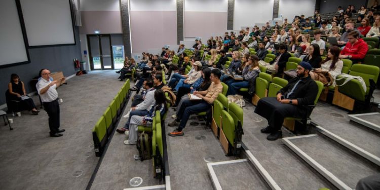 View from the side of the lecture theatre of Attorney general talking to audience of students