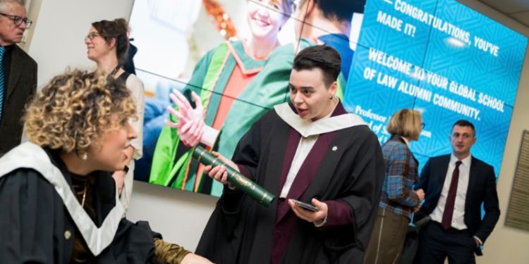 Dea chatting to another student at her graduation celebrations