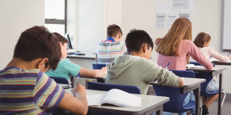Attentive school kids doing homework in classroom 
by WavebreakMediaMicro
