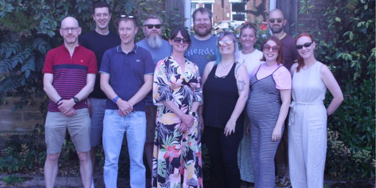 CIRCLE members standing near some greenery and smiling as a group.