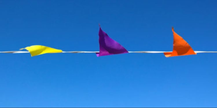 Three triangular flags attached against a bright blue background.