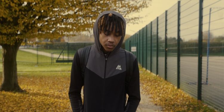 A young man walks on a path