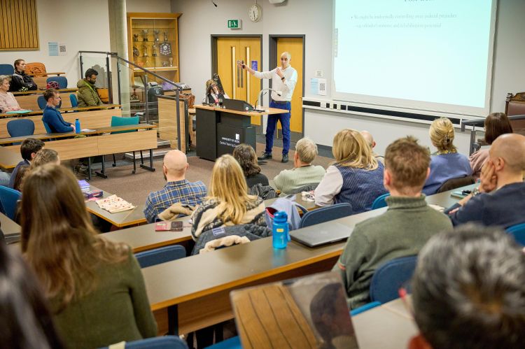 Audience watches Professor Pina-Sánchez delivering his lecture. 