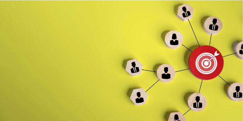 Image of a dartboard's bullseye surrounded by wooden counters illustrating people