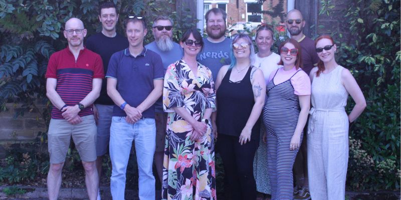 CIRCLE members standing in a group and smiling. Background of greenery.