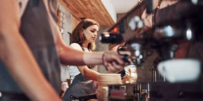 An image of a young woman working in a coffee shop via Adobe stock images